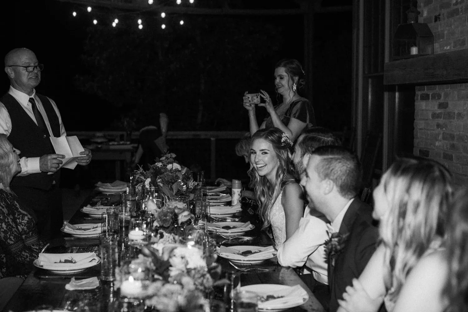 Wedding guests gathered around a candlelit dinner table
